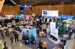High wide angle view of the Expo Hall, with attendees looking around booths, Expo Cafe