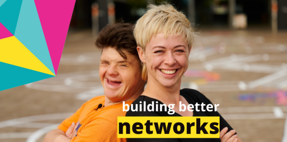A man and woman are standing back to back. The man has short dark hair and is wearing an orange shirt. The woman has short blonde hair and is wearing a black shirt. The words BUILDING BETTER NETWORKS are in the bottom of the image. A graphic element comprising pink, yellow and blues shapes is in the top left corner.