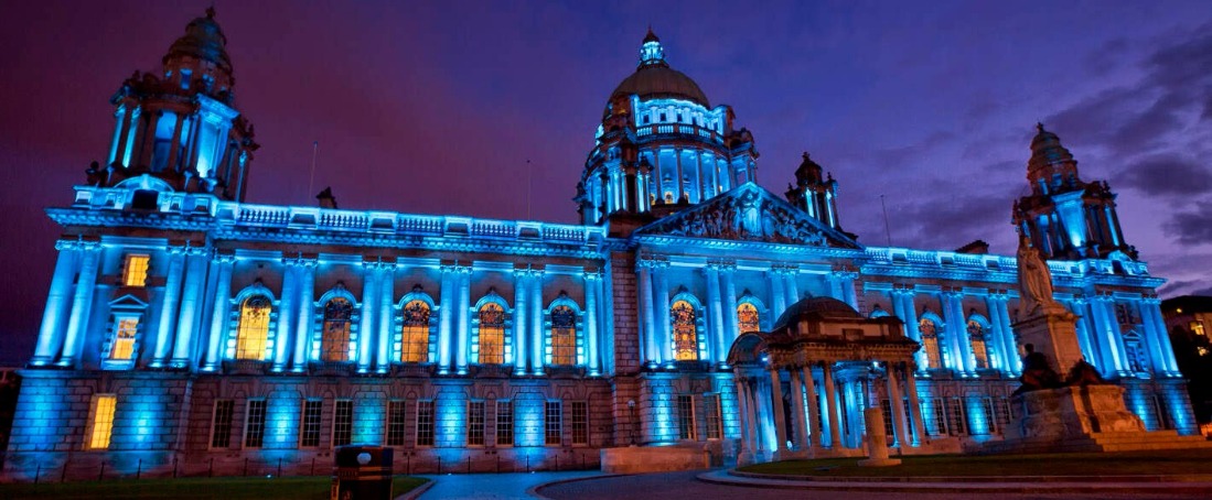 Belfast City Hall at night, lit blue lights and navy sky